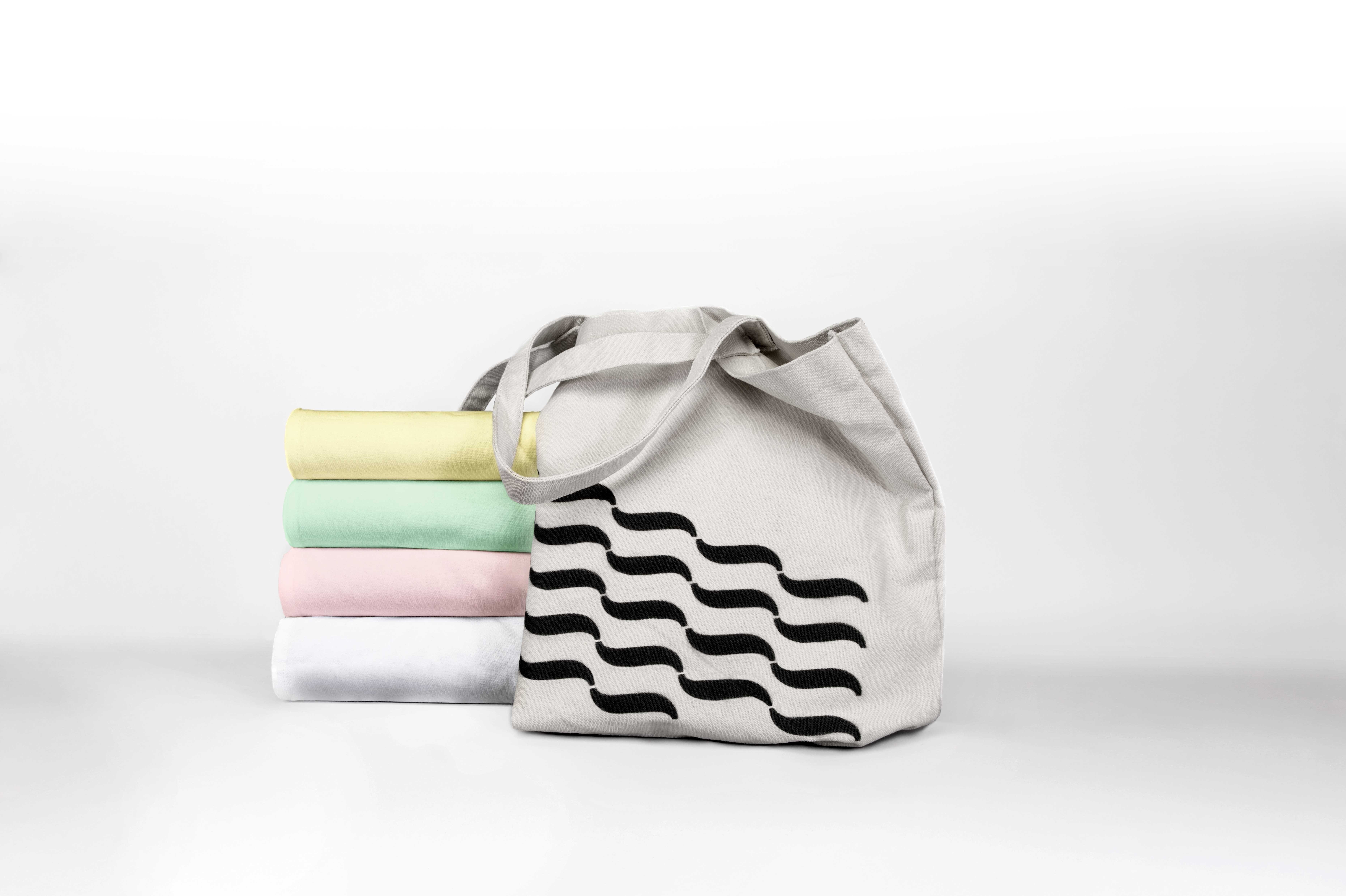 An Impressed branded bag along side linen in the brands colours 
