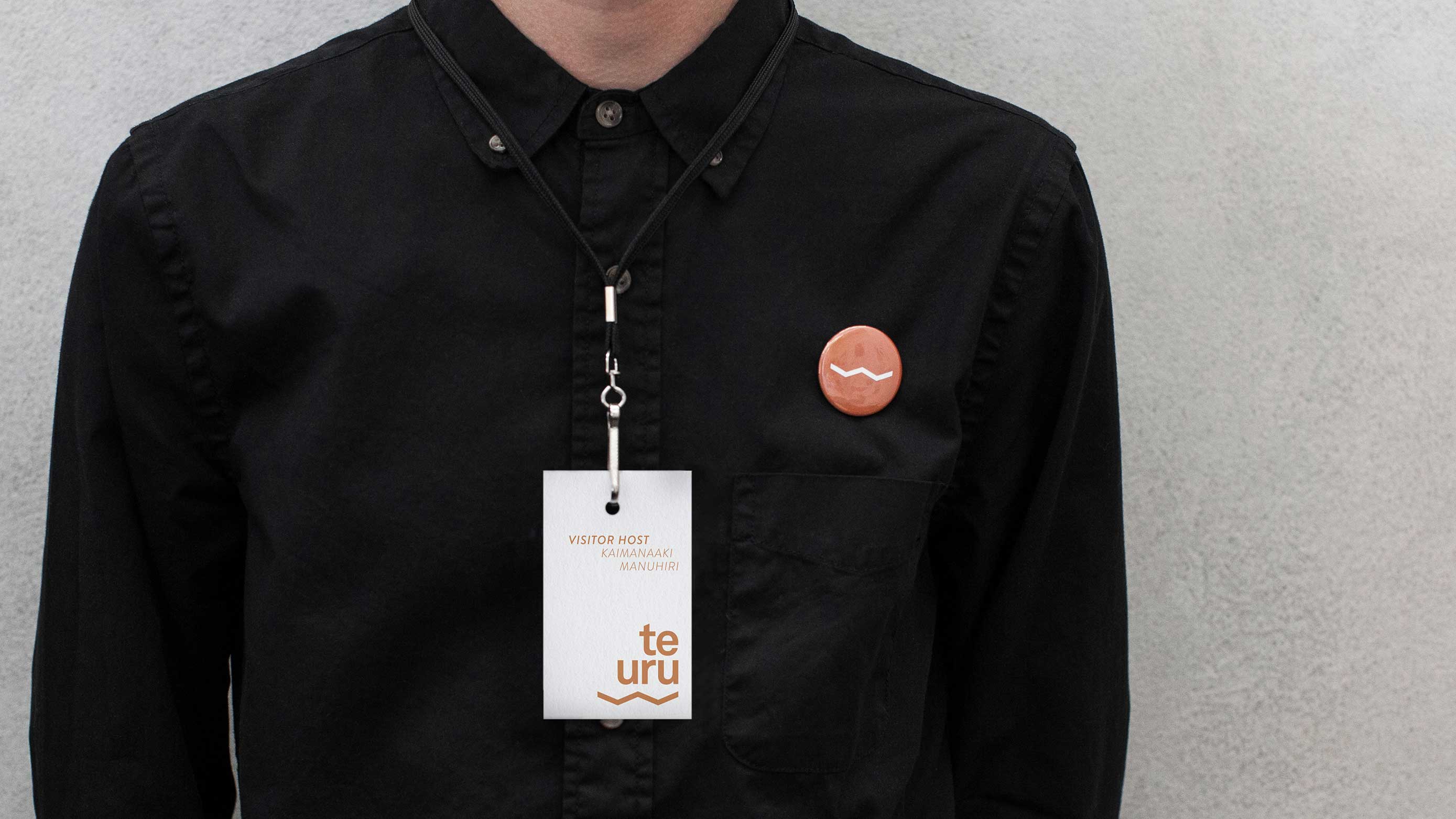 A gallery visitor wearing a Te Uru badge and gallery visitors pass